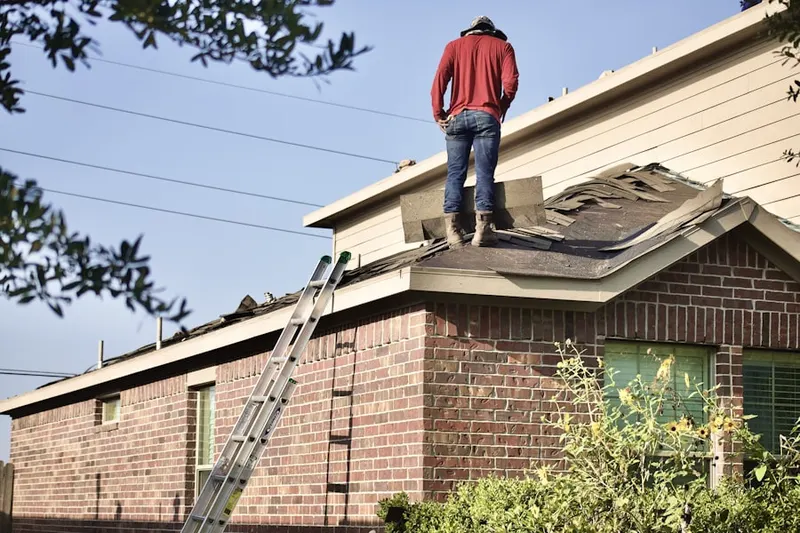 Professional roofer working on a residential roof in Romeo